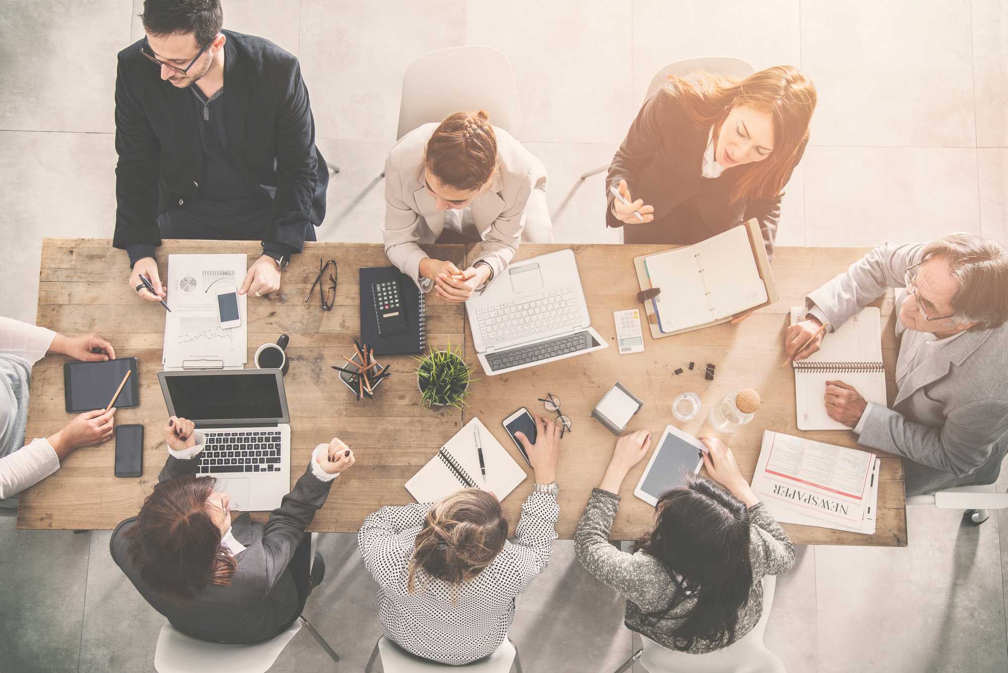 team at conference table from overhead, distant, tan